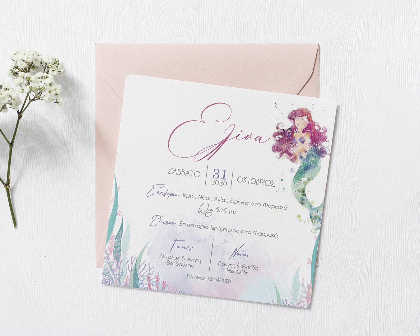 Square invitation with water color mermaid in pastel pink and greens on top of a light pink envelope on an off white background.