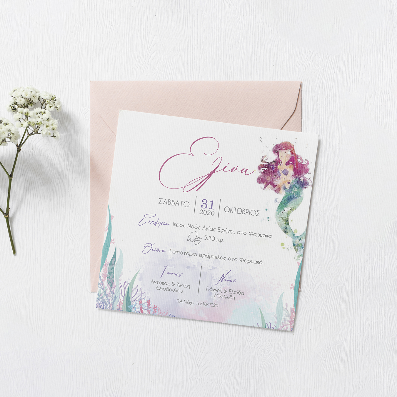Square invitation with water color mermaid in pastel pink and greens on top of a light pink envelope on an off white background.